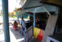 Rastst�tte an Jamaikas �berlandstrassen � Zigarettenpause unter wachsamen Blicken des Taxifahrers